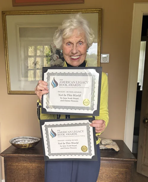 Jane Scott Stuart holding her 2026 American Legacy Book Awards certificates for Not In This World